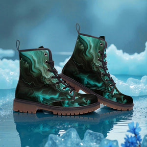 A pair of green and black patterned boots with a marbled design, placed on a surface with ice and blue flowers in the background.