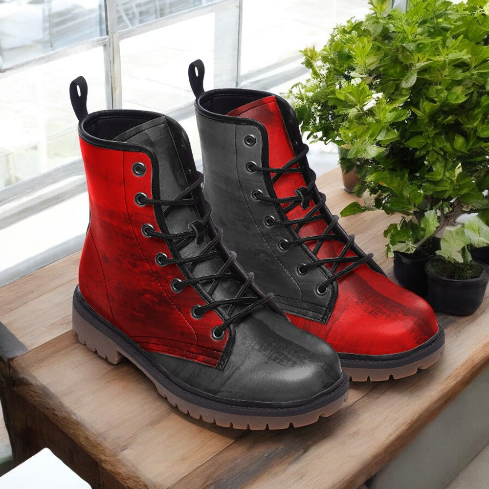 A pair of red and black combat boots are displayed on a wooden surface, with a potted plant in the background.