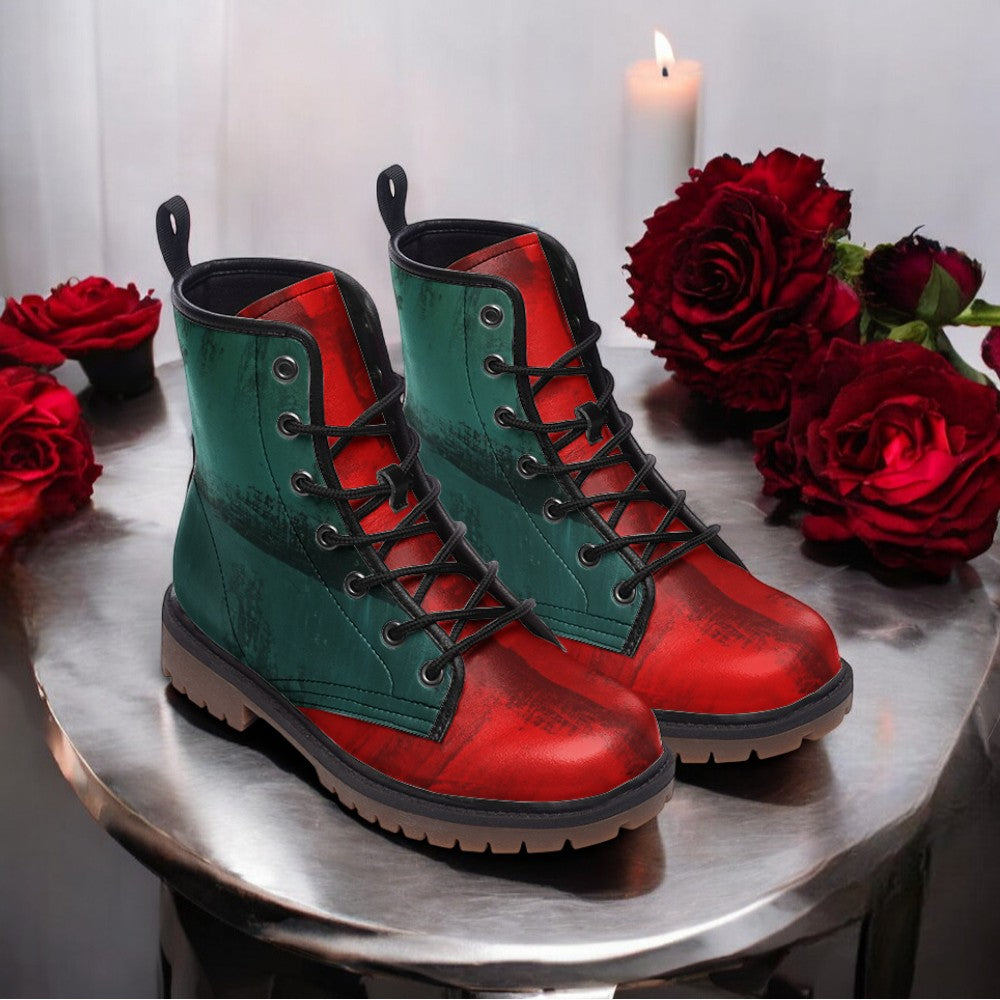 A pair of green and red boots with a floral pattern, placed on a silver surface, with red roses in the background.