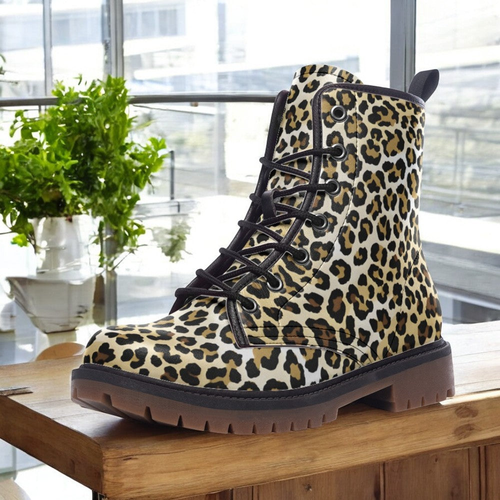 A leopard print boot is displayed on a wooden surface, with a potted plant visible in the background.