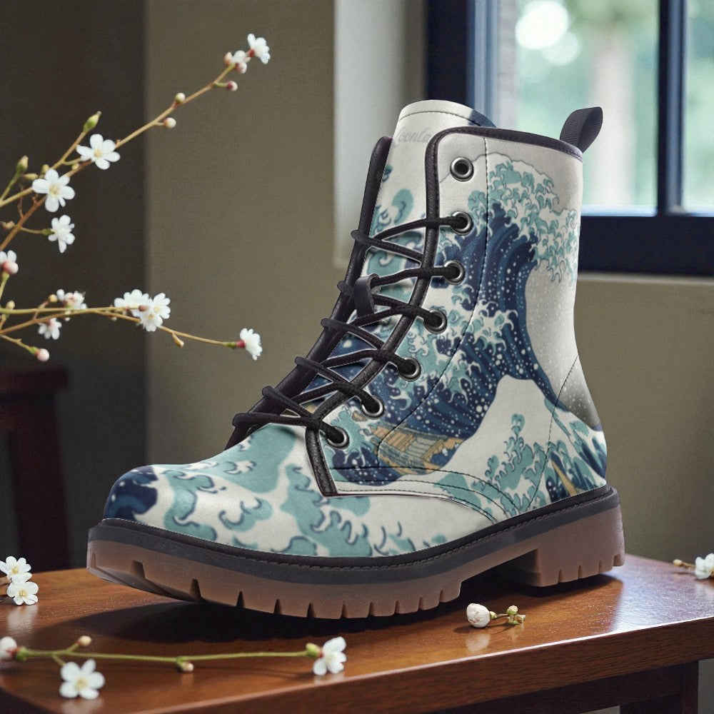 A pair of white and blue boots with a wave pattern design, placed on a wooden surface near a window with white flowers.