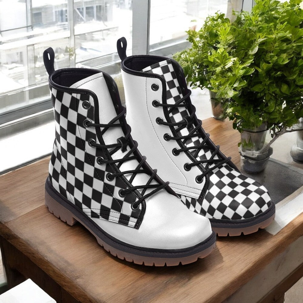 A pair of white and black checkered boots are displayed on a wooden surface, with a potted plant in the background.