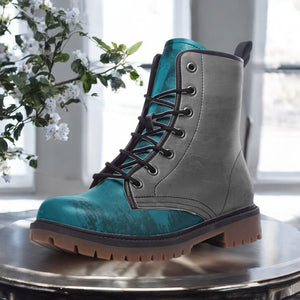 A teal and gray boot is displayed on a round table, with a plant in the background.