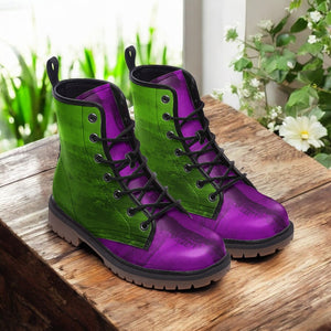 A pair of purple and green boots are displayed on a wooden surface, with a white flower visible in the background.