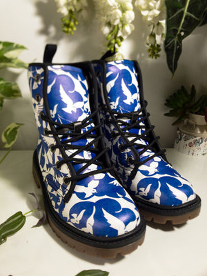 a pair of blue and white boots sitting on top of a table