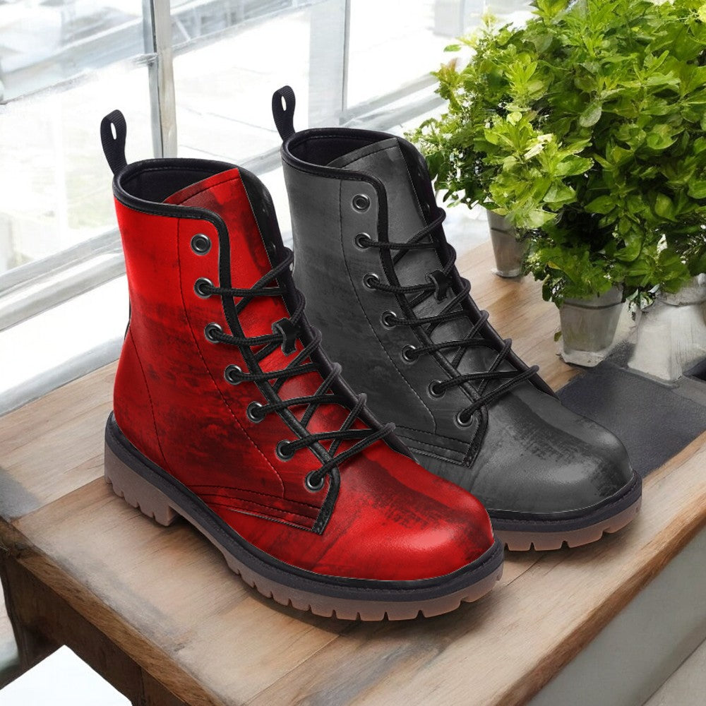 A pair of red and black combat boots are displayed on a wooden surface, with a potted plant visible in the background.