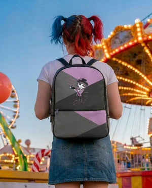 A person with red and blue hair is standing in front of a colorful carnival ride, wearing a backpack with a cartoon character design.
