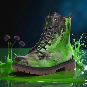 A green and black camouflage boot with a black lace and sole, standing on a green surface with purple flowers and a splash of green liquid behind it.