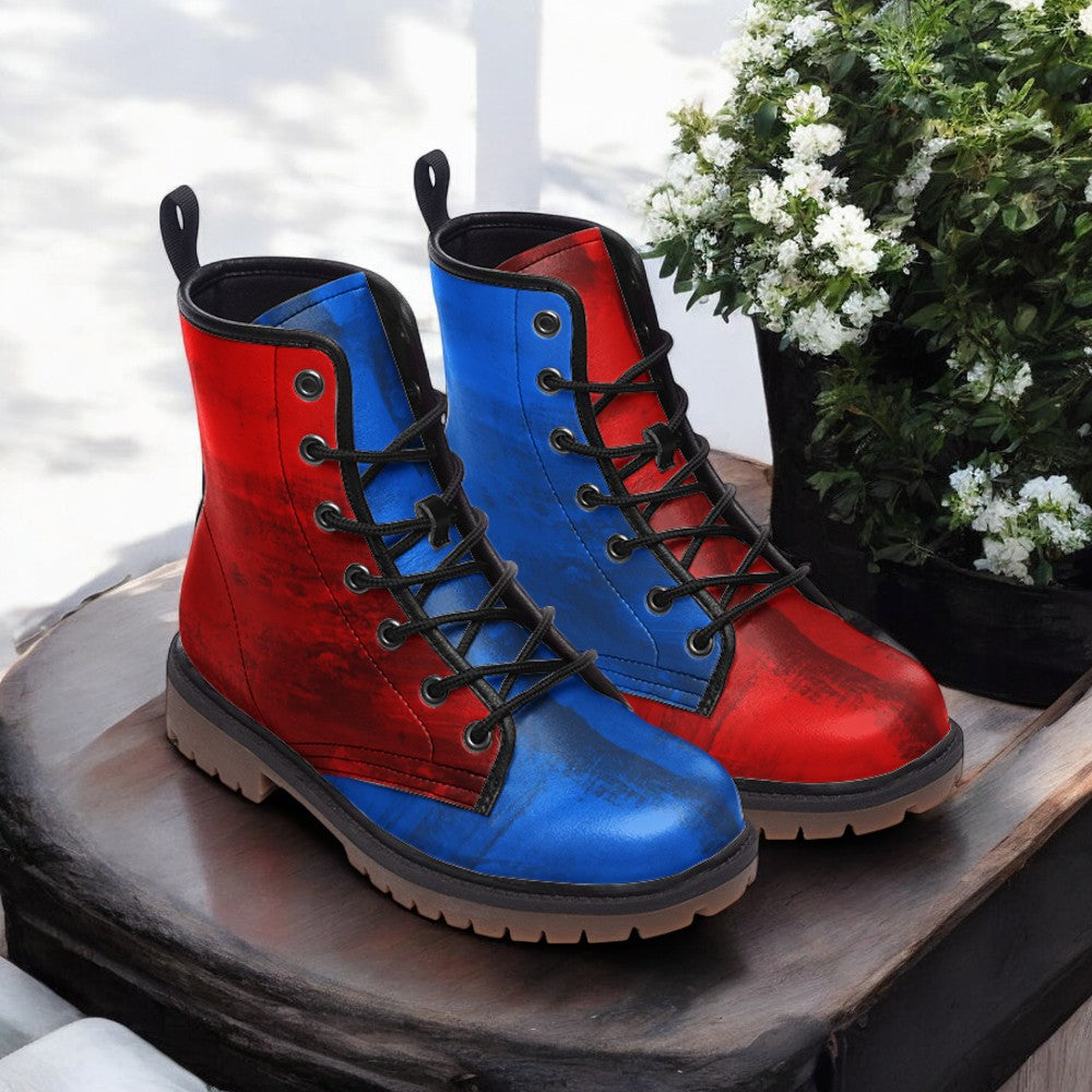 A pair of red and blue boots with black laces, placed on a wooden surface next to a potted plant with white flowers.