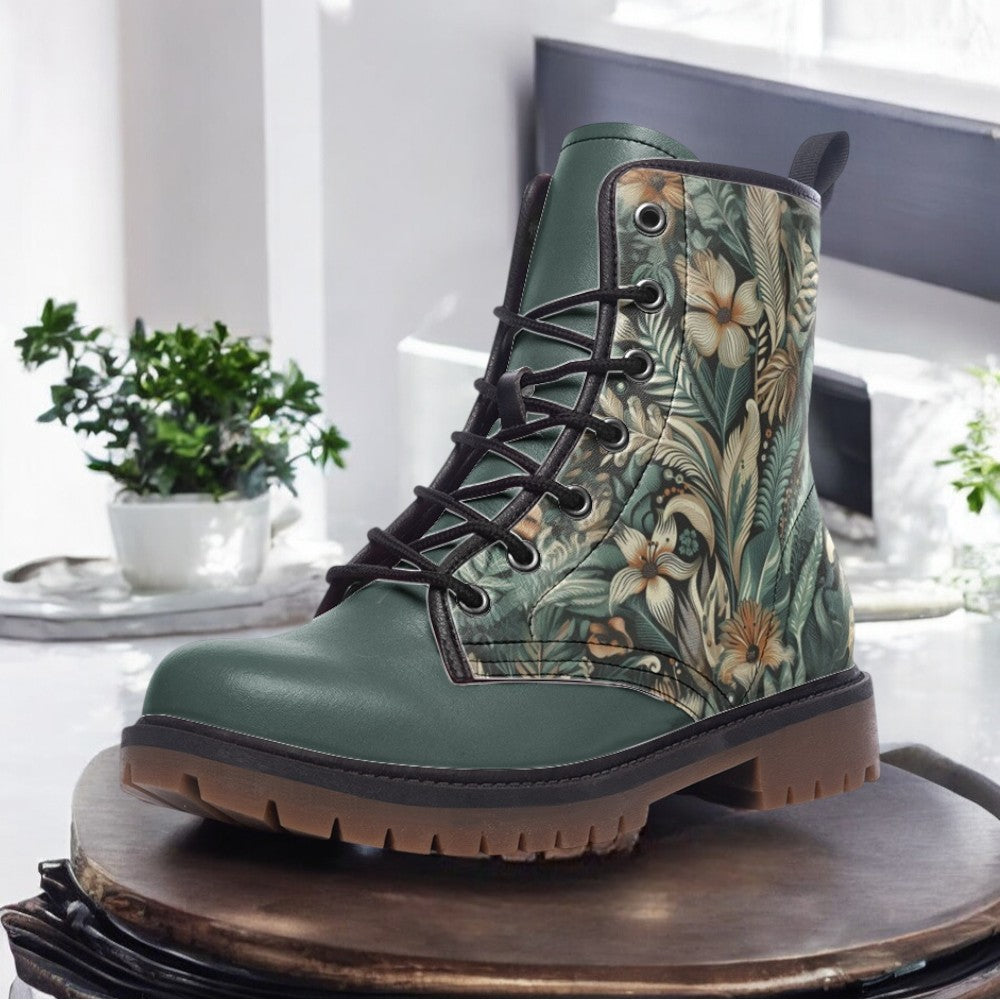 A pair of green boots with a floral print pattern on the side, placed on a wooden surface.