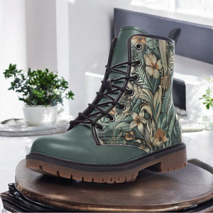 A pair of green boots with a floral print pattern on the side, placed on a wooden surface.