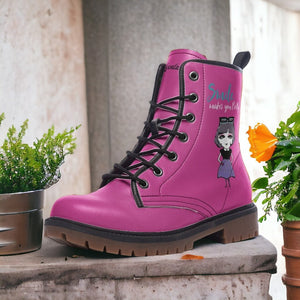 a pair of pink boots sitting next to a potted plant