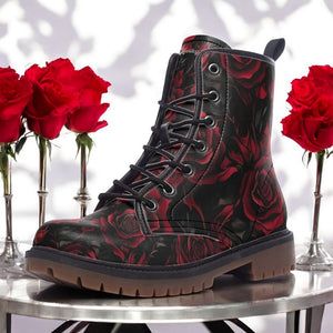 a pair of black boots with red roses on a table