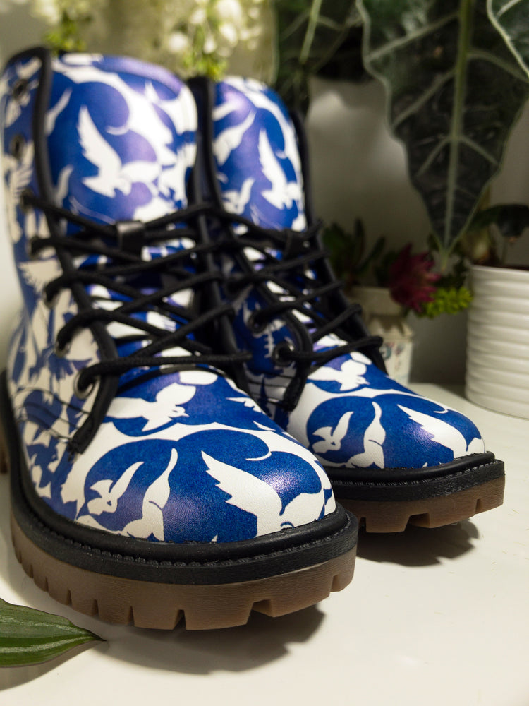 a pair of blue and white boots sitting on top of a table