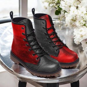 A pair of red and black combat boots are displayed on a table, with white flowers in the background.