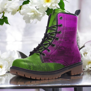A purple and green combat boot is displayed on a reflective surface, surrounded by white flowers.
