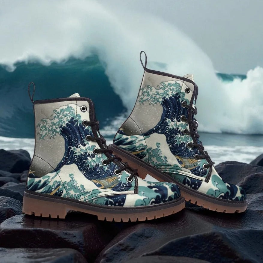 A pair of colorful boots with a wave-themed design, placed on a rocky surface with a large wave crashing in the background.